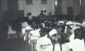 Interior da antiga escola de Burela nunha clase coa mestra e as alumnas.  
